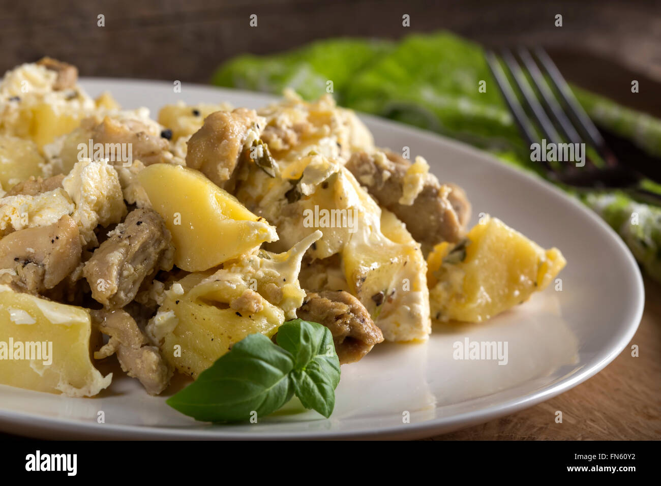 Kartoffelgratin mit Sahne, Käse und Hühnerfleisch gebraten in Butter auf hölzernen Hintergrund Stockfoto