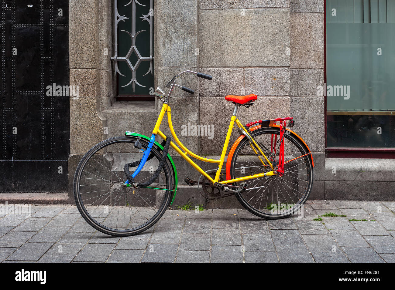 Bunte Fahrrad lehnt an der Wand in Amsterdam, Niederlande. Stockfoto