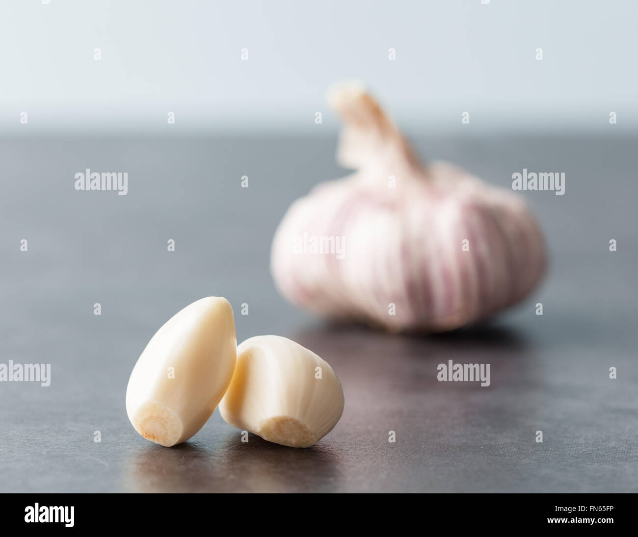 Nahaufnahme von zwei geschälte Knoblauchzehen mit unscharfen Knoblauch im Hintergrund. Geringe Schärfentiefe. Stockfoto