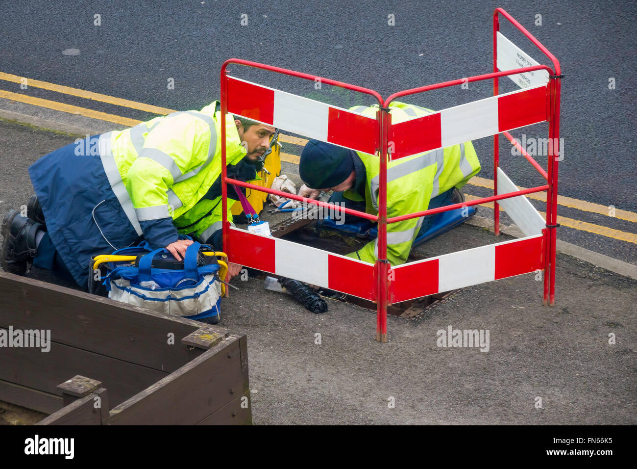Zwei BT-Service Telefon Techniker arbeiten in einem Schacht, ein defekter Hausanschluss reparieren Stockfoto