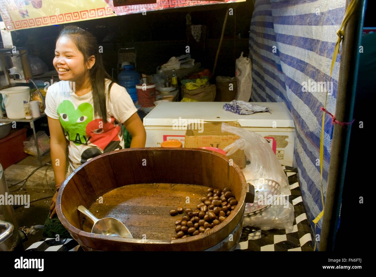 Eine Frau verkauft Kaffeebohnen aus Thailand, die in einer Holzschale auf einer Straße Messe in Kampong Cham, Kambodscha angezeigt werden. Stockfoto