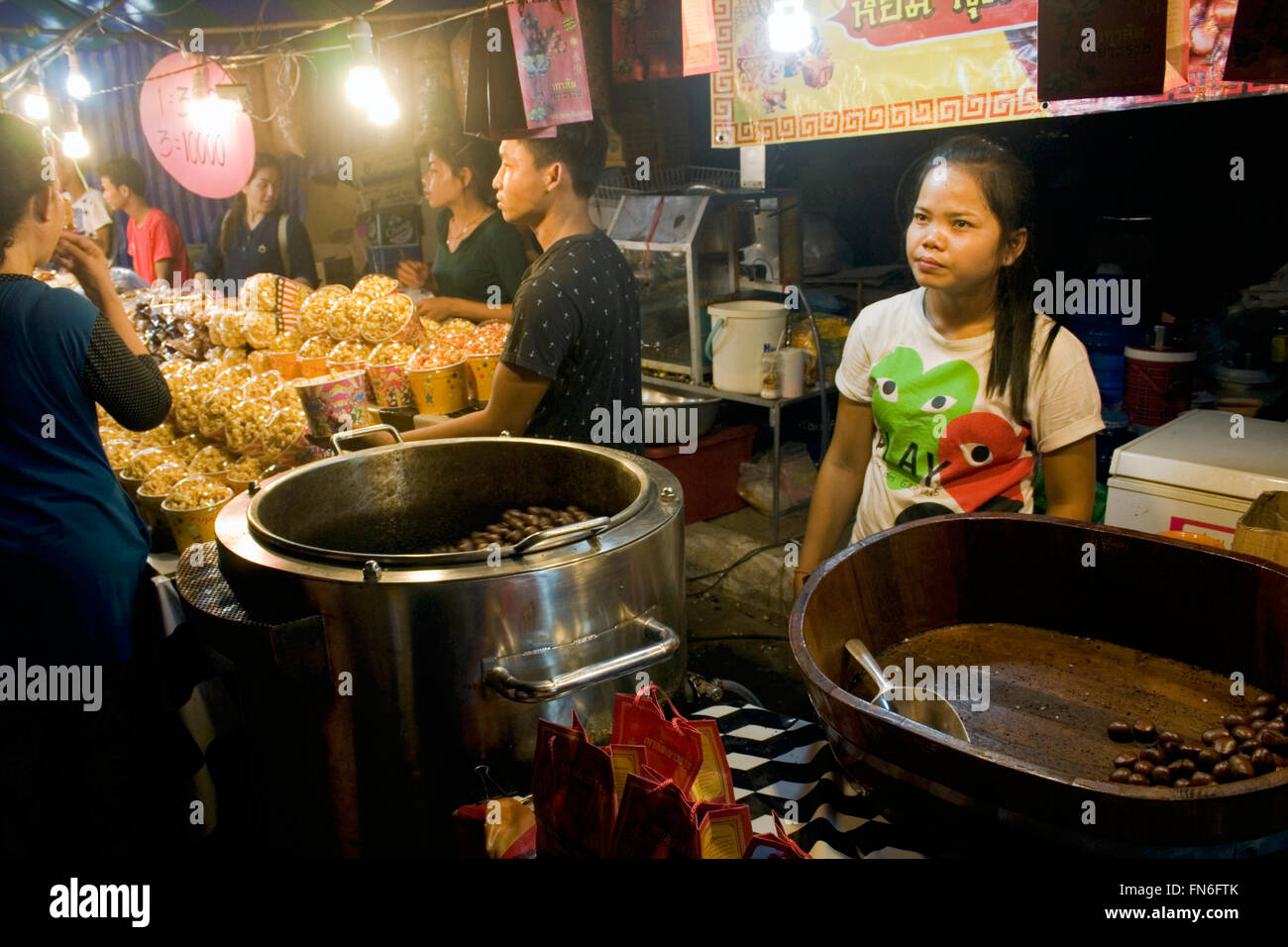 Eine Frau verkauft Kaffeebohnen aus Thailand, die in einer Holzschale auf einer Straße Messe in Kampong Cham, Kambodscha angezeigt werden. Stockfoto
