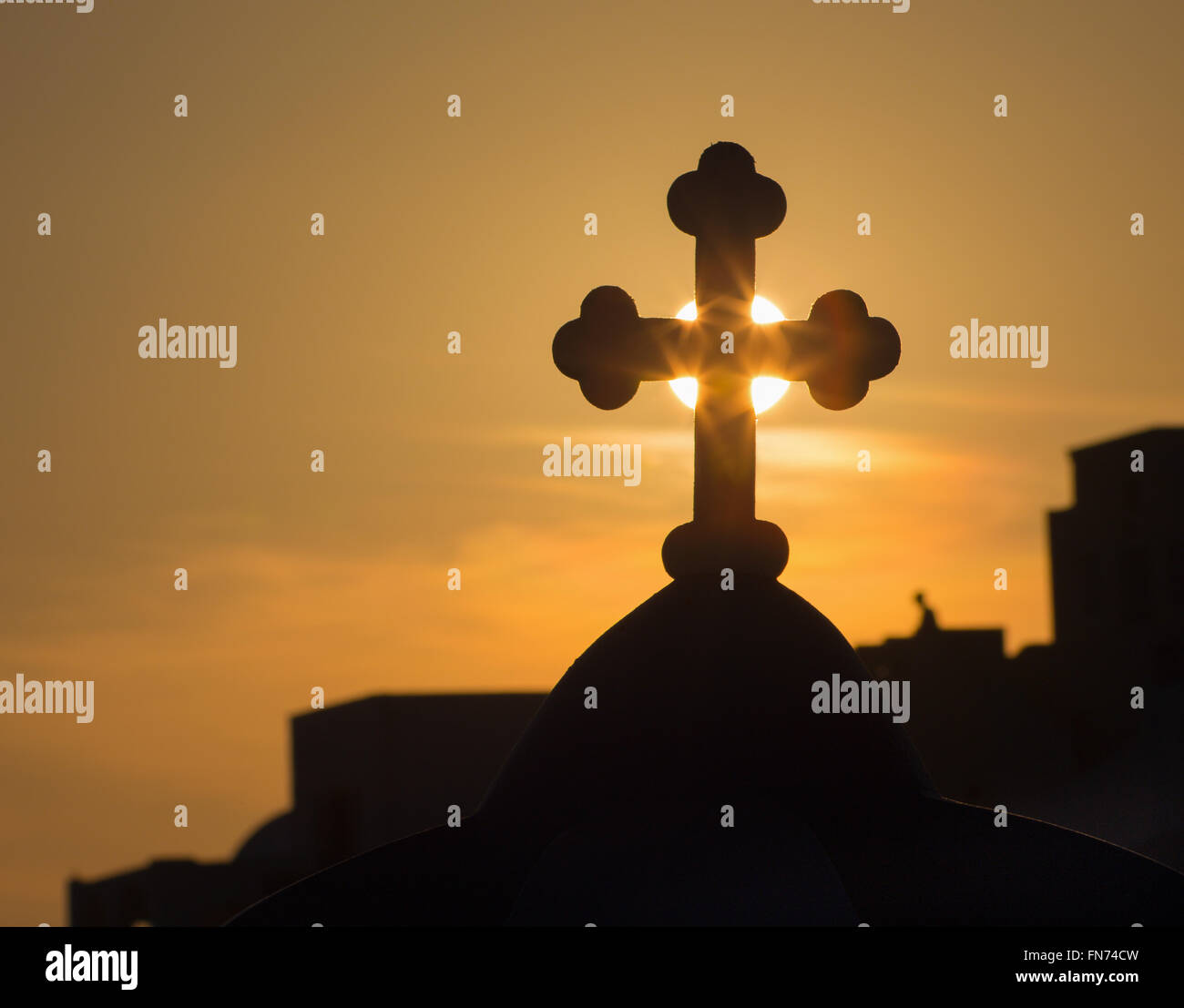 Santorini - die Silhouette des Kreuzes in der Regel Kirche Kuppeln in Oia in der Sonnenuntergang Sonne. Stockfoto