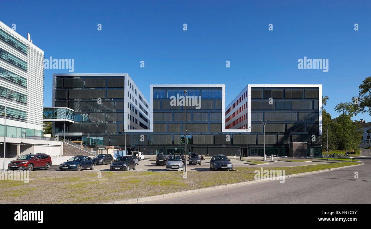 Fernen Vorderansicht mit Parkplatz. Oslo Krebs Cluster (OCCI), Oslo, Norwegen. Architekt: Dunkle Arkitekter, 2015. Stockfoto