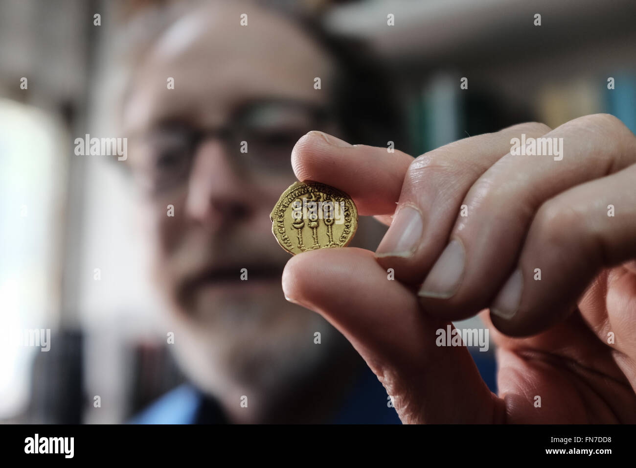 Jerusalem, Israel. 14. März 2016. Dr. DONALD ARIEL, Leiter Kurator des Fachbereichs Münze an der Israel Antiquities Authority, hält eine seltene Goldmünze zeigt die Symbole der römischen Legionen neben dem Namen des Herrschers Trajan auf dem Rücken, und tragen das Bild des Kaisers Augustus auf Vorderseite. 107 in Rom geprägt war CE die Münze Teil einer Reihe von Kaiser Trajan als eine Hommage an die römischen Kaiser, die ihm vorausgegangen geprägt. Bildnachweis: Nir Alon/Alamy Live-Nachrichten Stockfoto