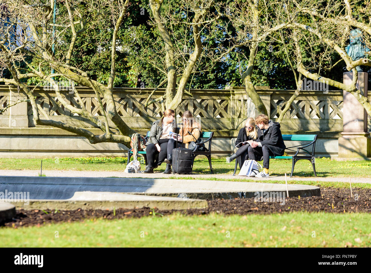 Lund, Schweden - 12. März 2016: Unbekannten jungen Erwachsenen Personen beim betrachten Broschüren oder Kataloge auf Parkbank sitzen. Die uni Stockfoto