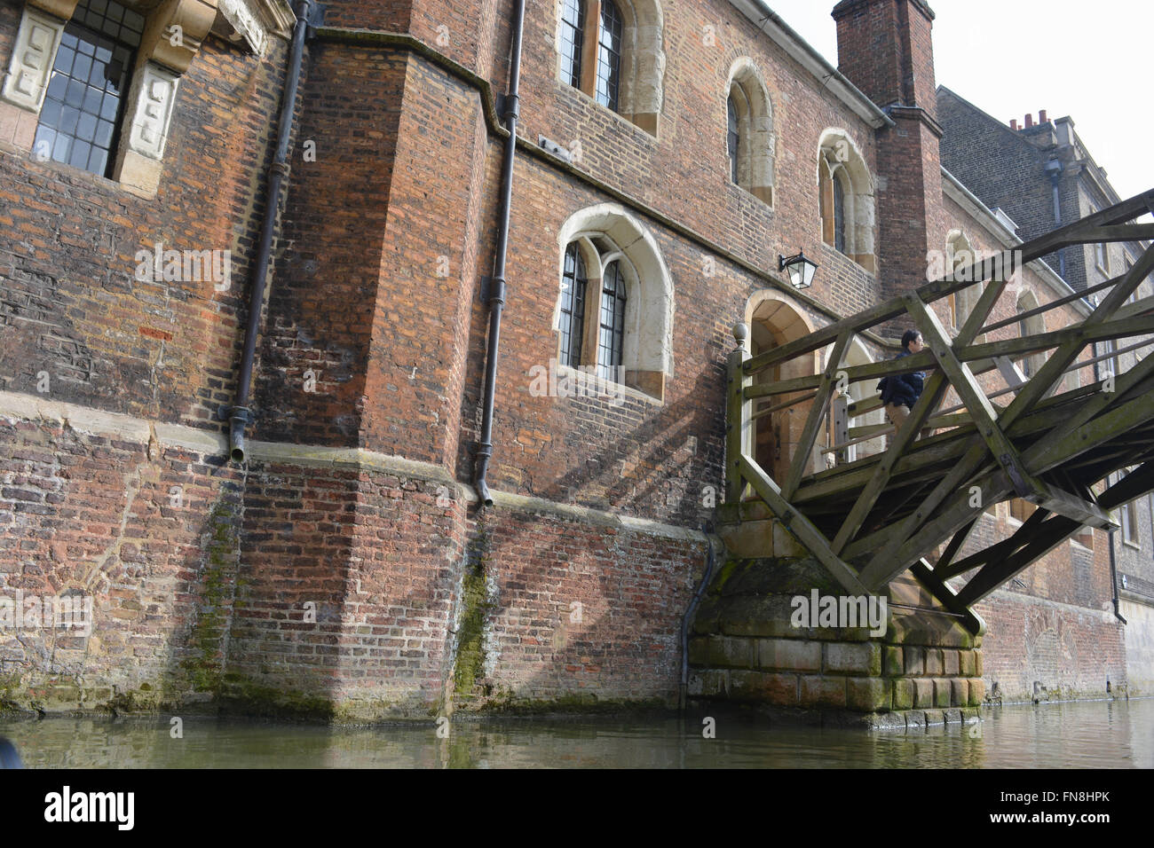 Mann auf die Mathematical Bridge über den Fluss Cam, verbinden zwei Teile des Queens' College der Universität Cambridge, England. Stockfoto