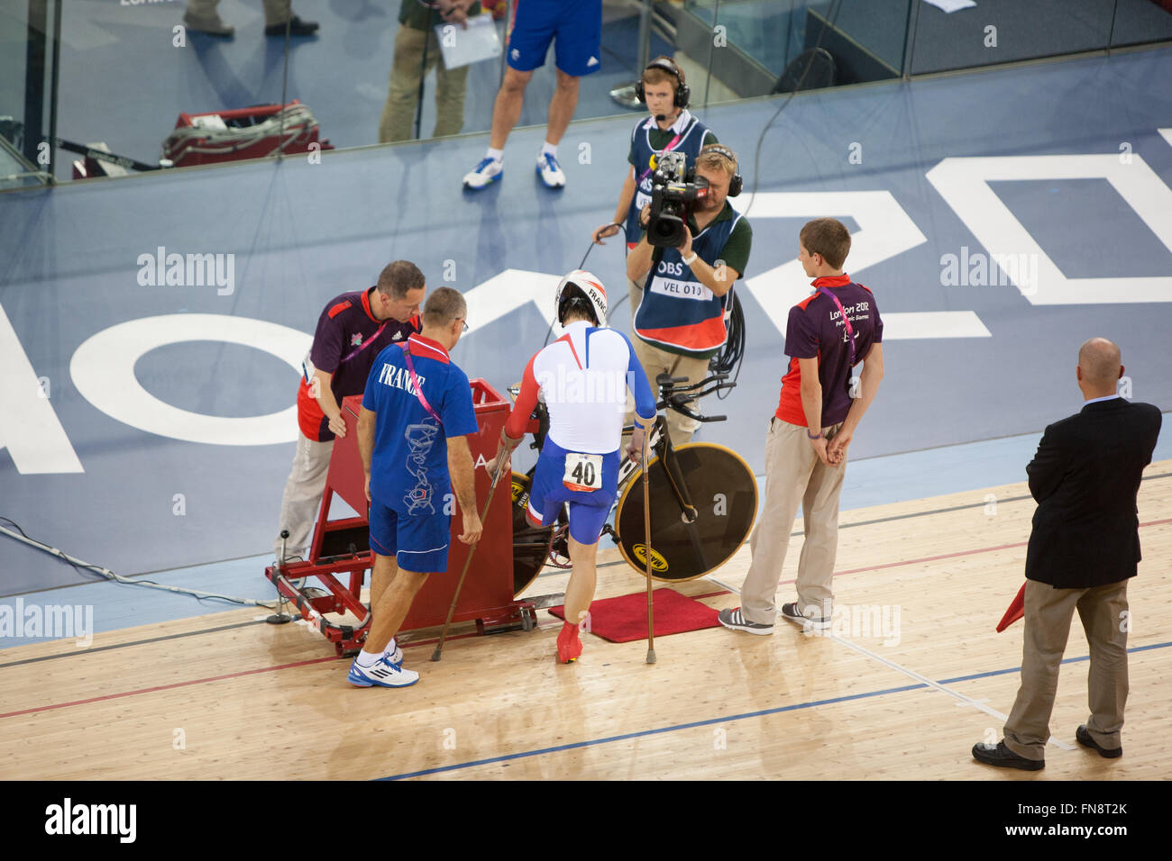 Französischer Radrennfahrer auf Krücken zu montieren sein Fahrrad bei Paralympics, London, 2012, England, UK, Europa. Stockfoto