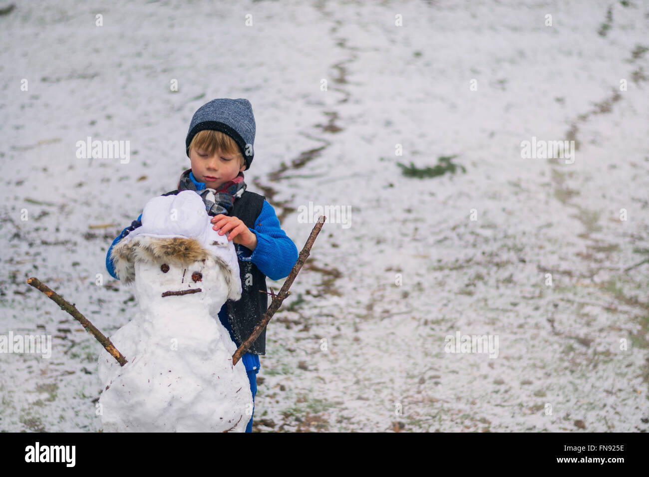 Junge macht einen Schneemann Stockfoto