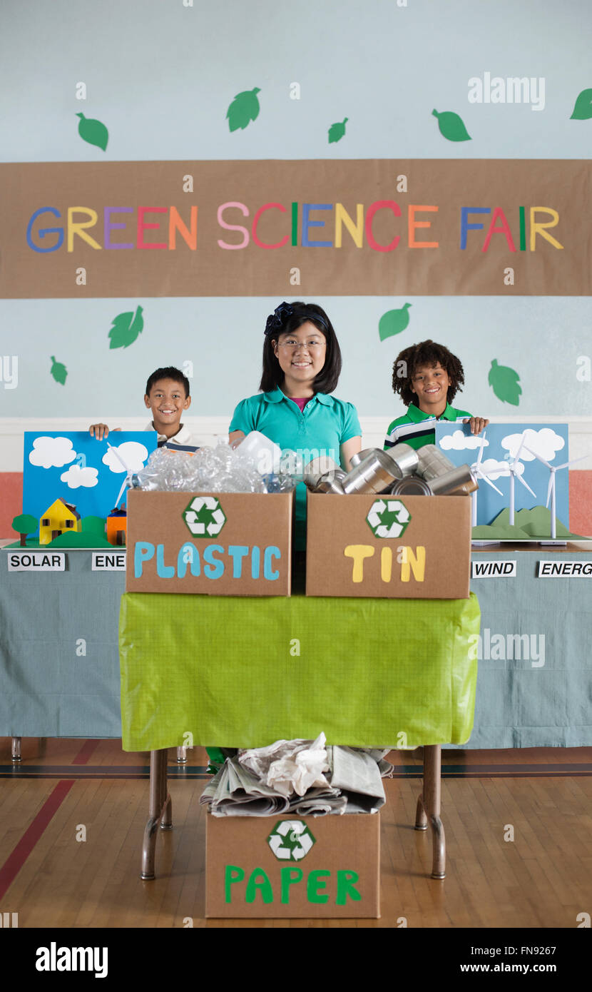 Drei Kinder stehen hinter Präsentationen auf der Green Science Fair. Stockfoto