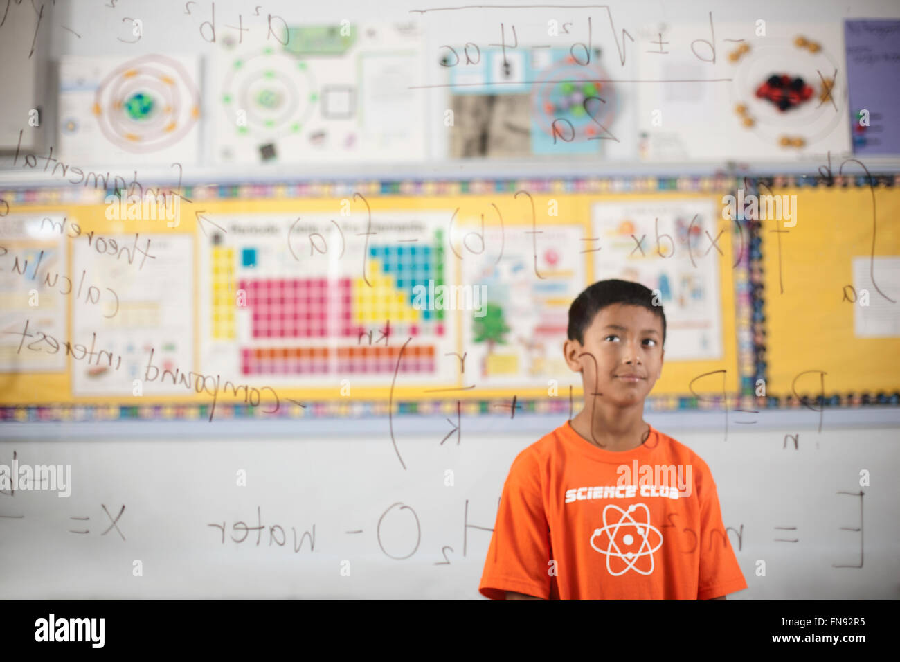 Ein Junge, ein klares durchsichtiges Board zeigt wissenschaftliche Formeln und Berechnungen zu betrachten. Stockfoto