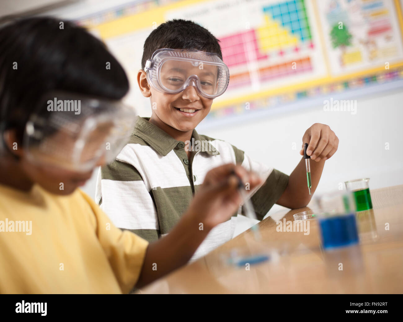 Zwei Jugendliche, jungen und Mädchen in einer Wissenschaft Lektion Schutzbrille tragen und arbeiten an einem Experiment. Stockfoto