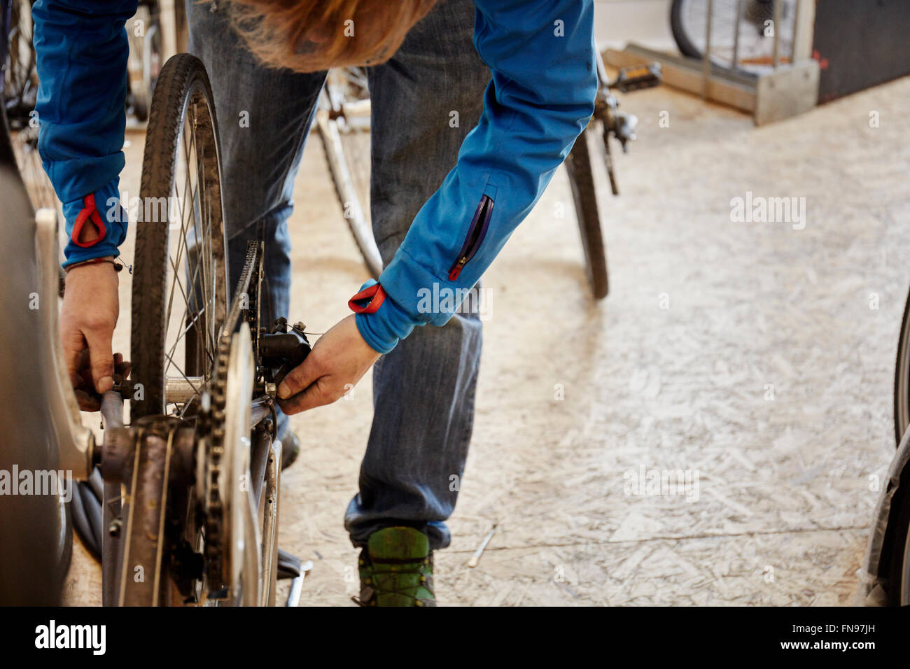 Ein junger Mann arbeitet in einem Zyklus-Shop, ein Fahrrad zu reparieren. Stockfoto