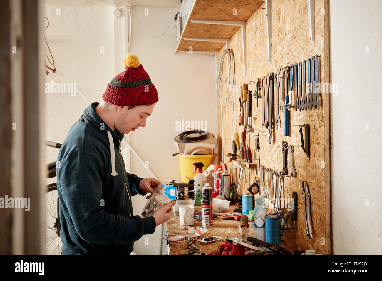 Ein junger Mann arbeitet in einem Zyklus-Shop, ein Fahrrad zu reparieren. Stockfoto