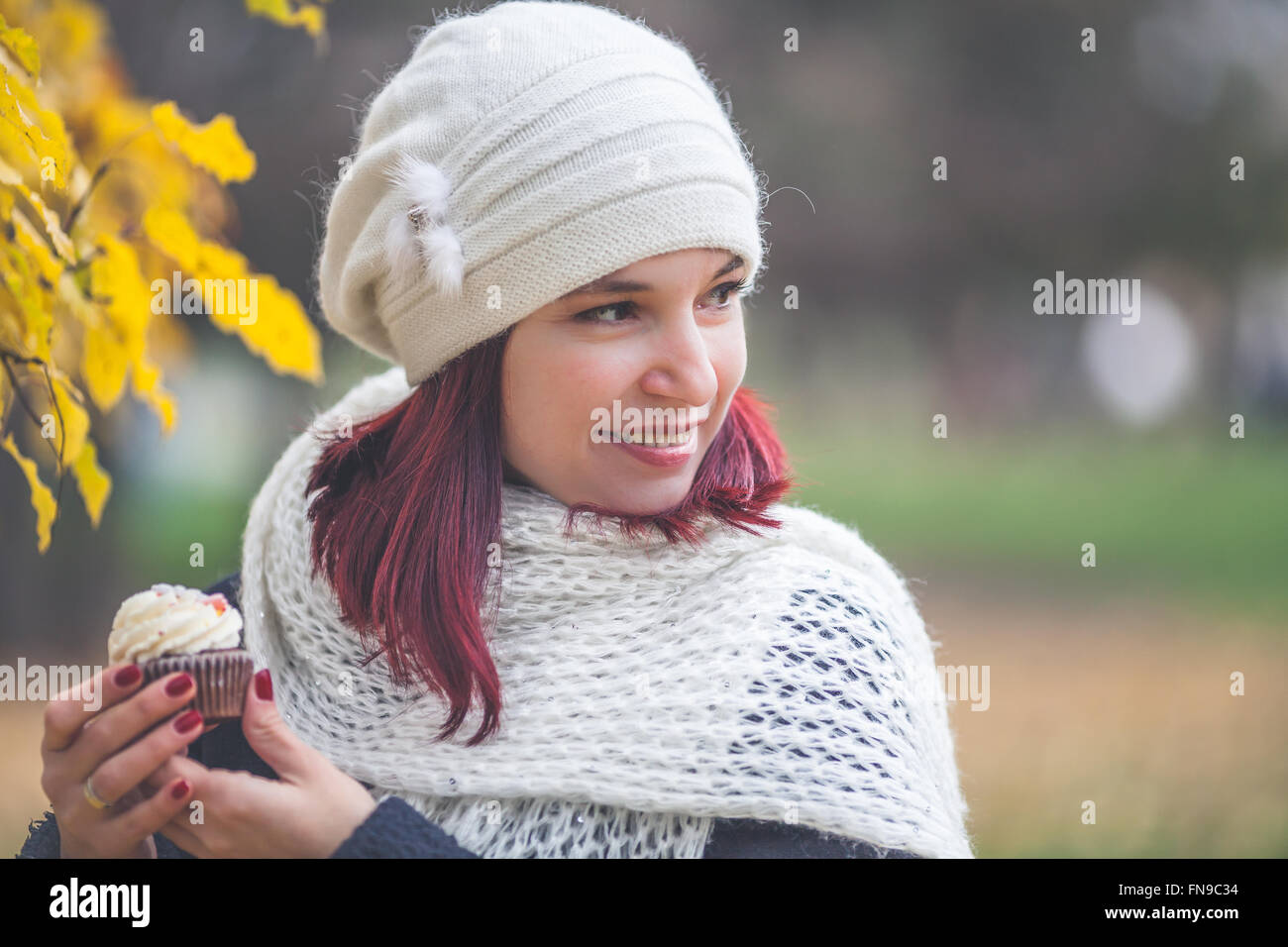 Porträt einer Frau mit Kuchen im park Stockfoto