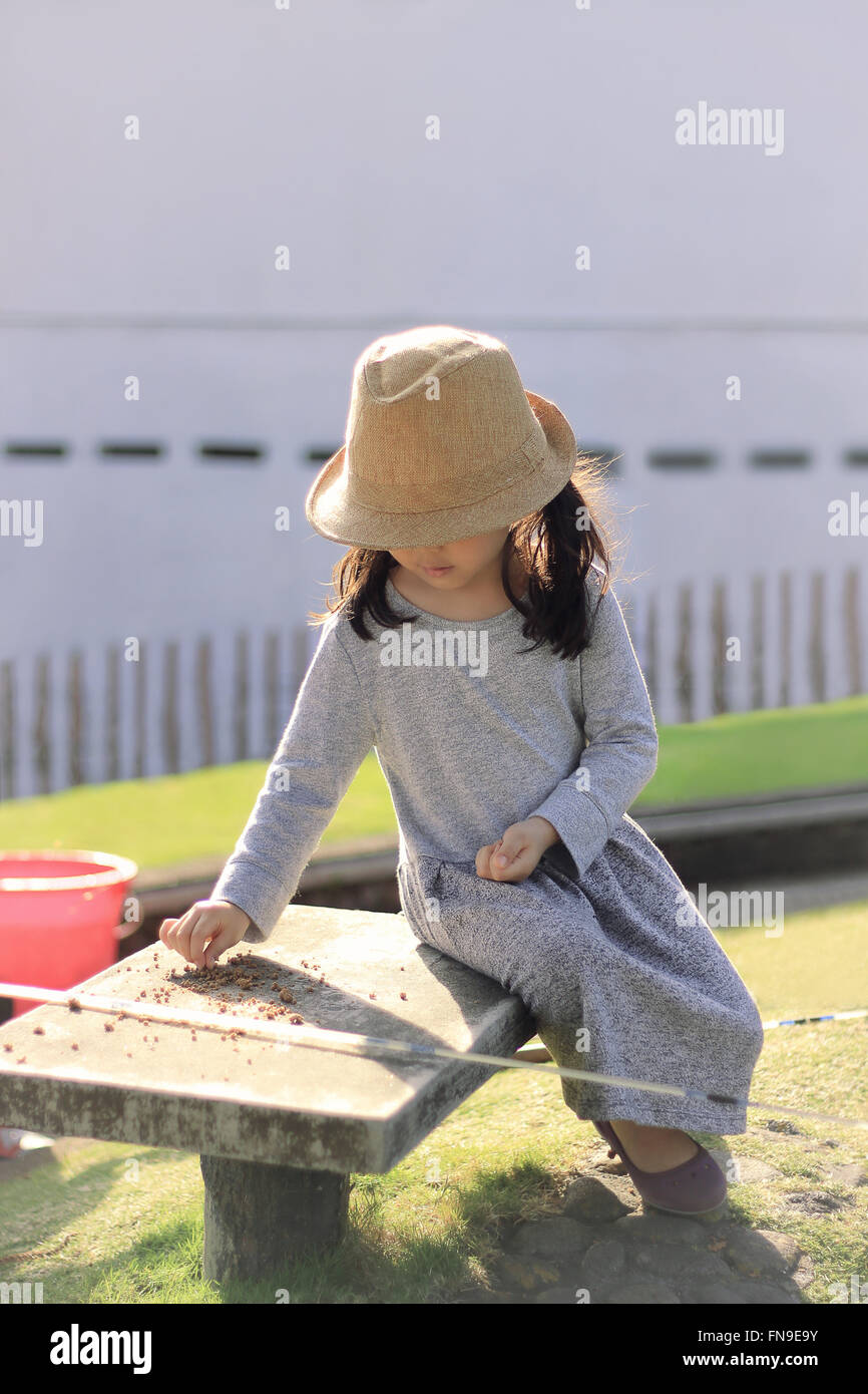 Mädchen sitzen im Freien mit Angelausrüstung Stockfoto