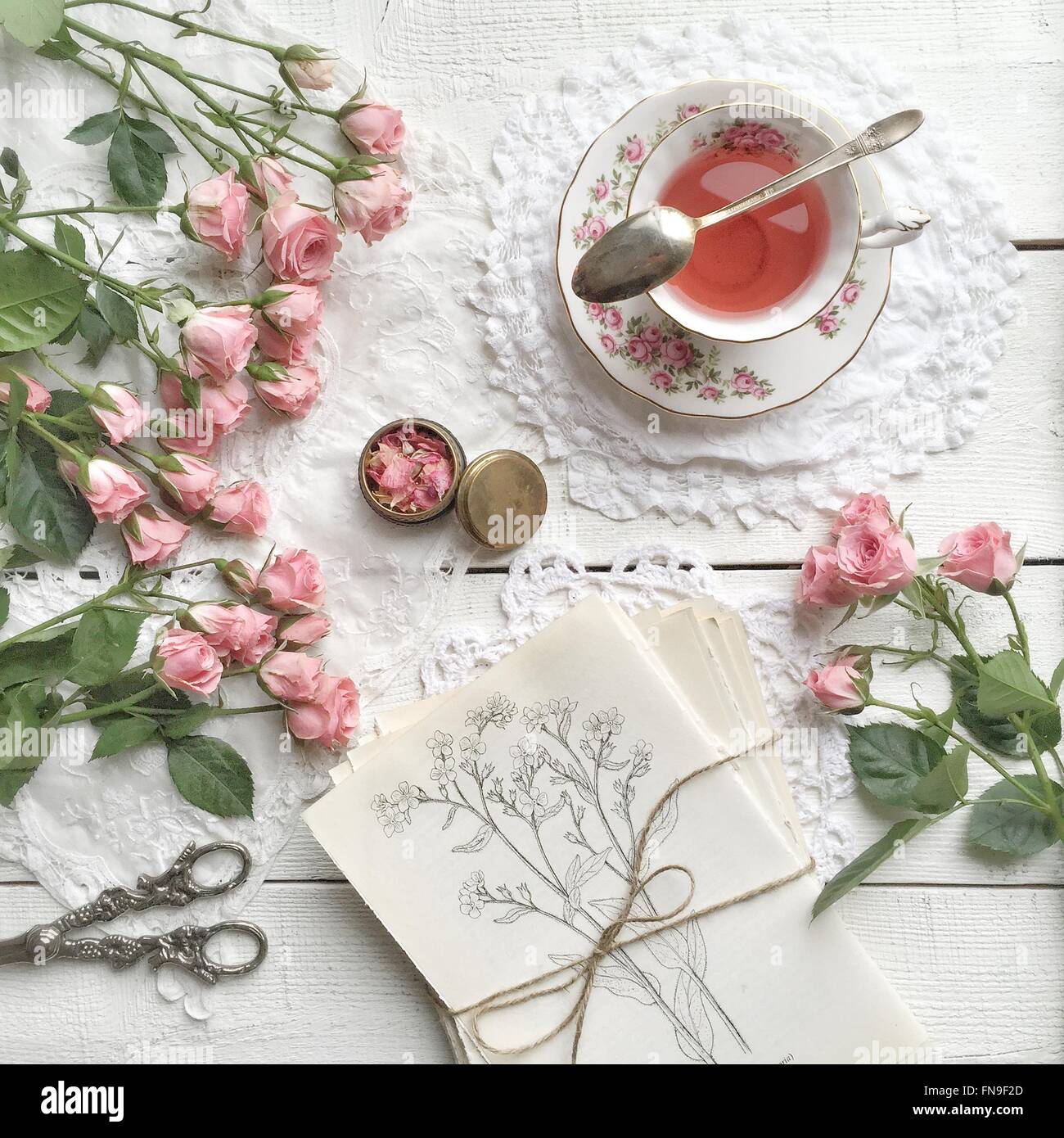 Rosa Rosen und eine Tasse Tee Stockfoto
