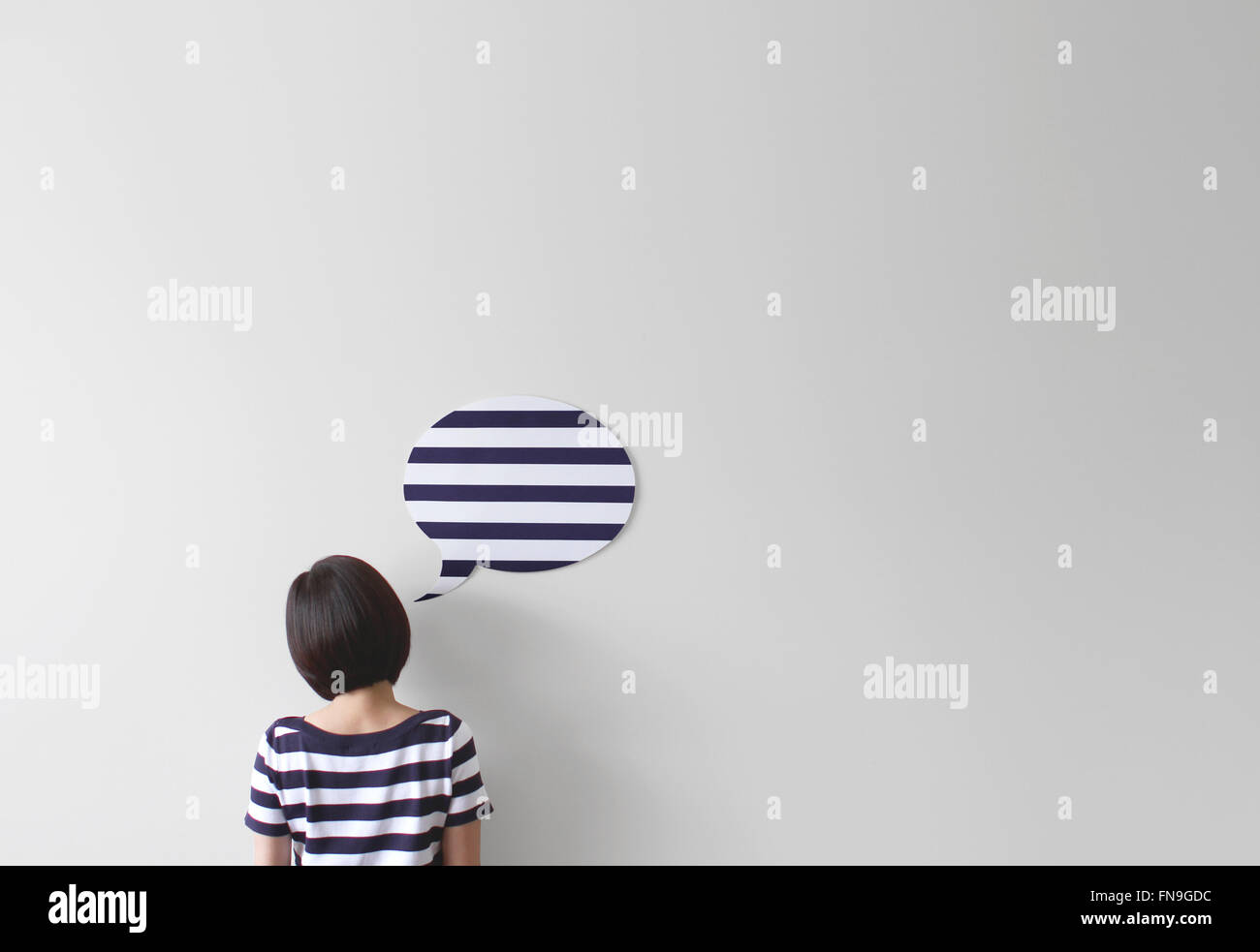 Rückansicht einer Frau in gestreiften Oberteil mit einer stripey Sprechblase Stockfoto