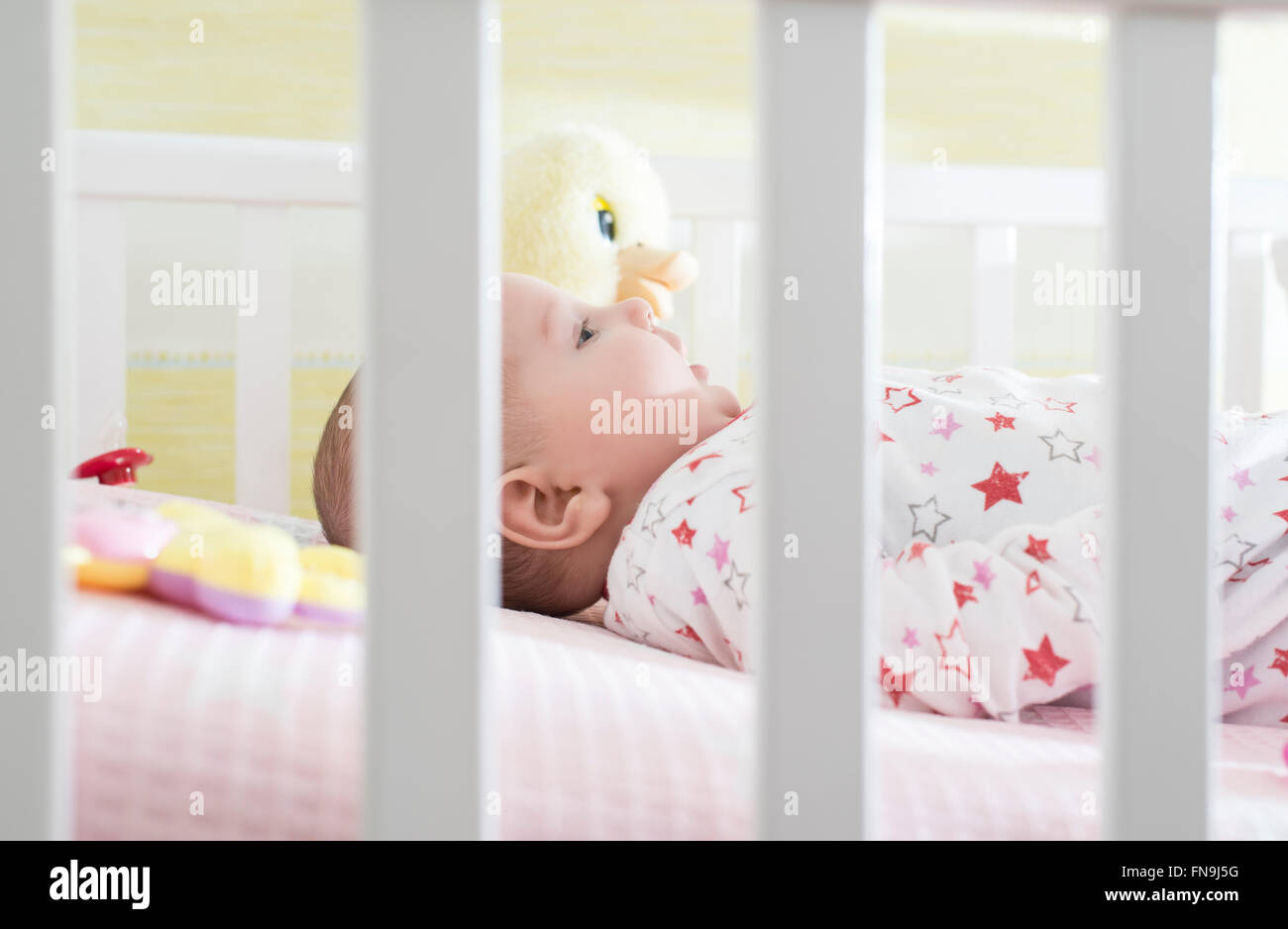Babymädchen im Kinderbett liegen Stockfoto