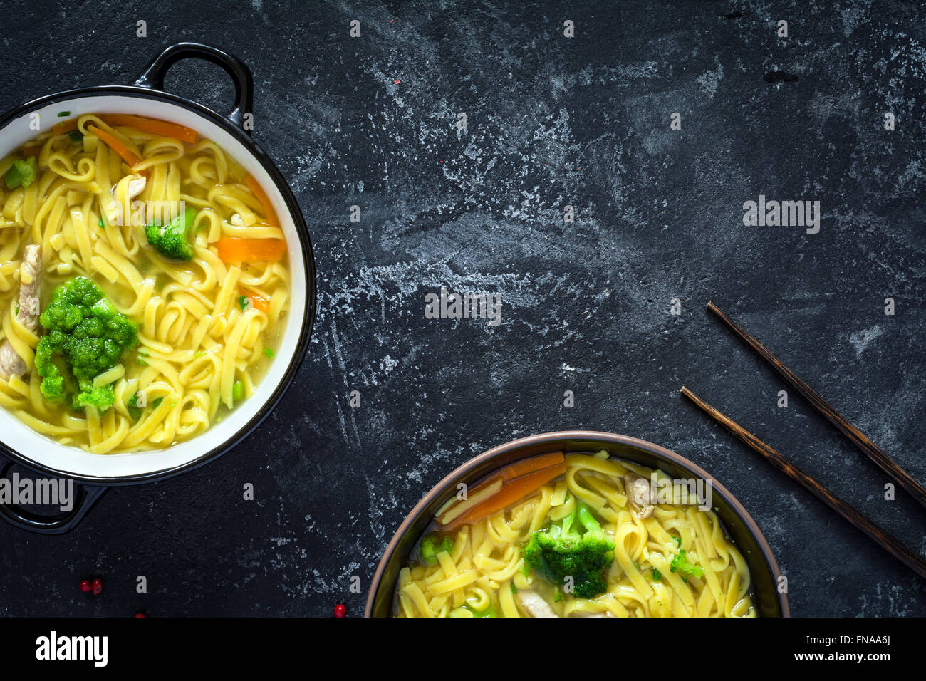 Asiatische Ei Nudelsuppe mit Gemüse und Schweinefleisch auf dunklem Schiefer. Ansicht von oben Stockfoto