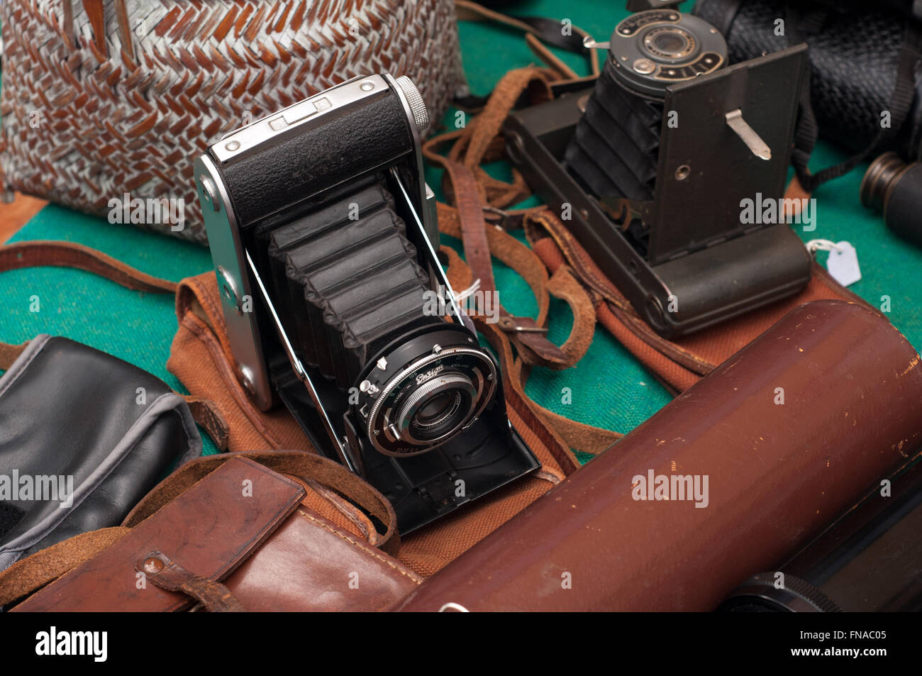 Alte Vintage Press Falten Retro-Kamera im Fall Lederbeutel auf Fotografie Marktstand bei Carboot Verkauf in Bath, Großbritannien. Stockfoto