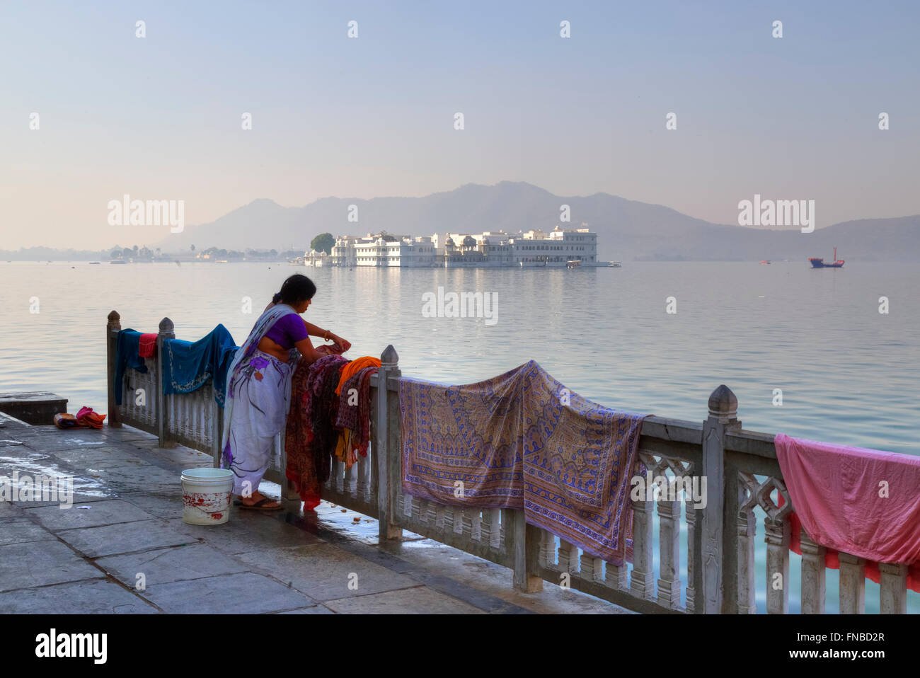 Frau, die Wäsche im Pichola-See, Lake Palace, Udaipur, Rajasthan, Indien Stockfoto