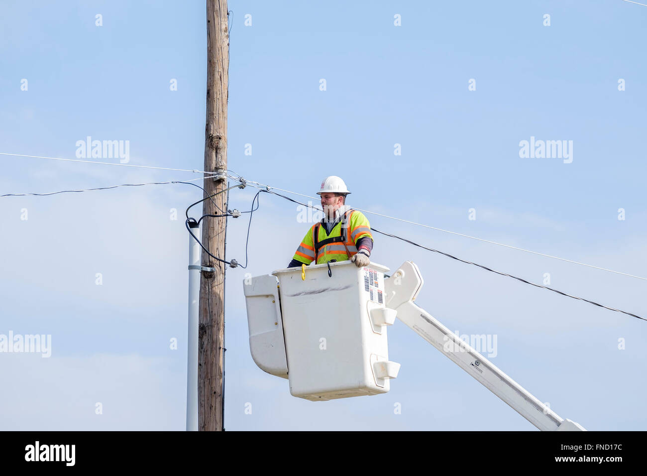 Ein störungssucher wird auf den Boden in einem Lift Schaufel nach der Instandsetzung einer elektrischen Leitung abgesenkt. Oklahoma City, OK, USA. Stockfoto