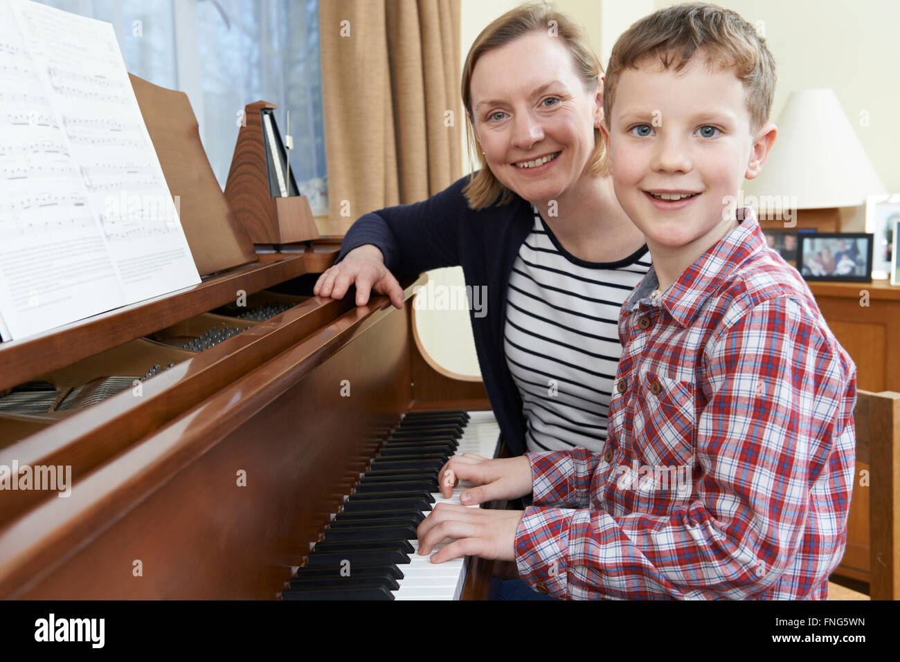 Junge mit Musiklehrer mit Unterricht am Klavier Stockfoto