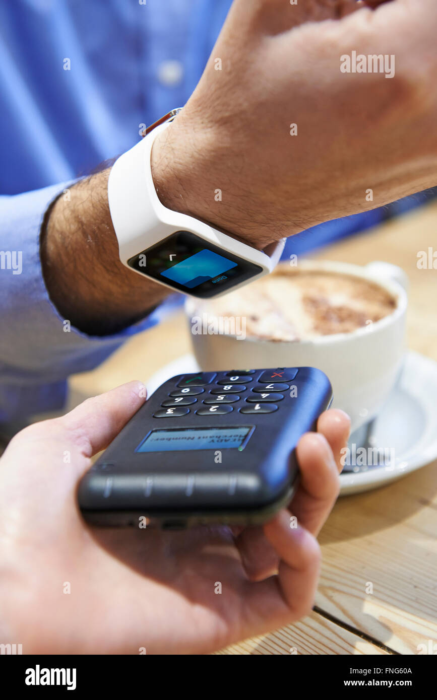 Man zahlt In Coffee-Shop mit Contactless Payment-App auf dem Smart Watch Stockfoto