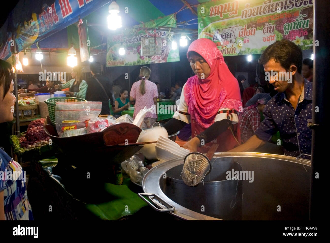 Eine muslimische Frau verkauft Essen Kunden an einer Straßenecke Messe in Kampong Cham, Kambodscha. Stockfoto