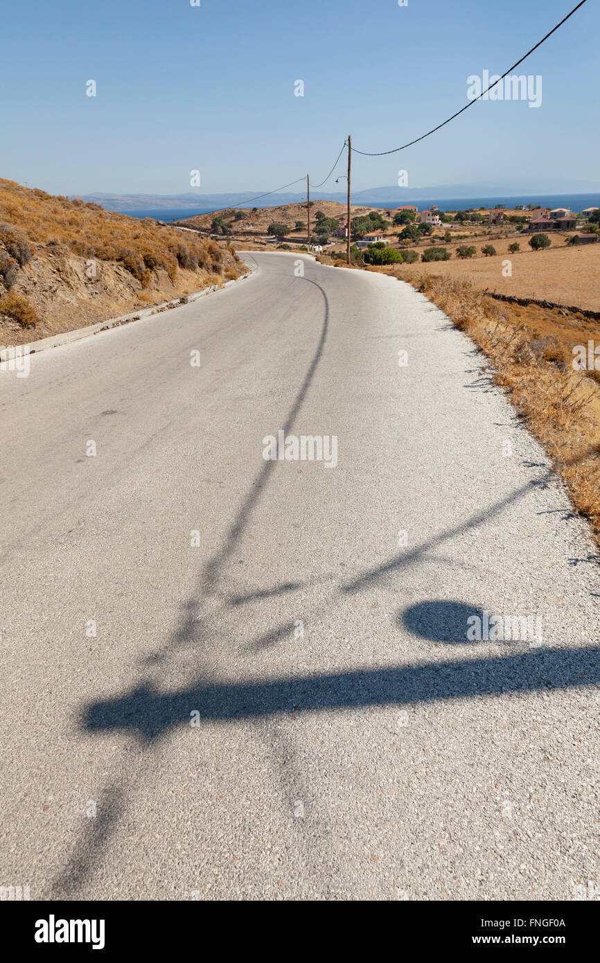 Einsame Straße mit Schatten in der Hitze des Tages Stockfoto