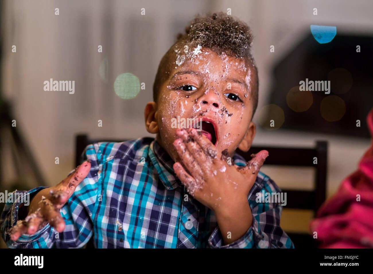 Schwarze Kind bedeckt in Kuchen. Stockfoto