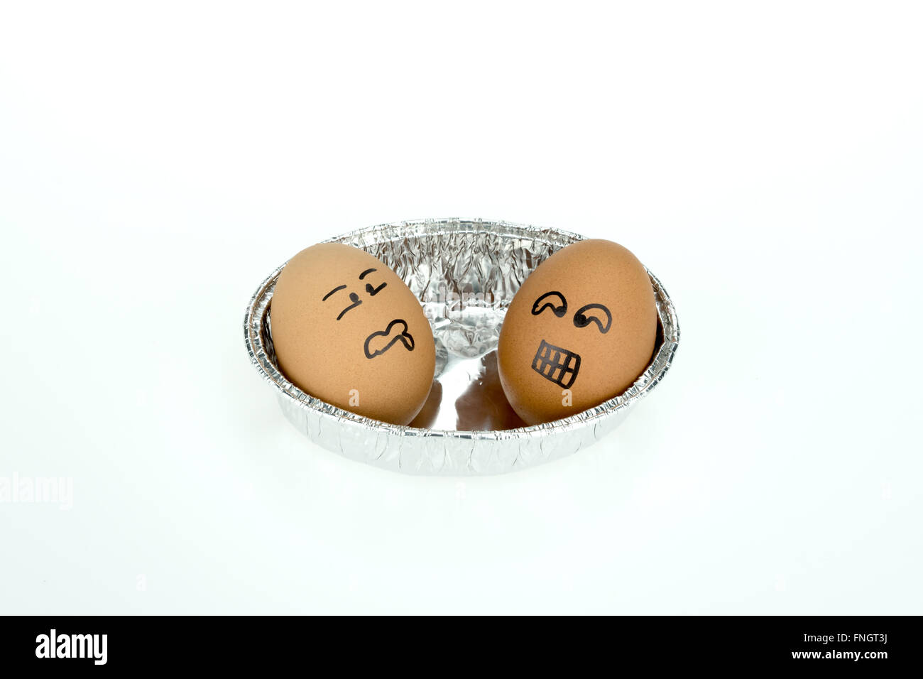 Ei mit lustigen Gesichtern auf ovale Folie Tablett, isoliert auf weißem Hintergrund Stockfoto