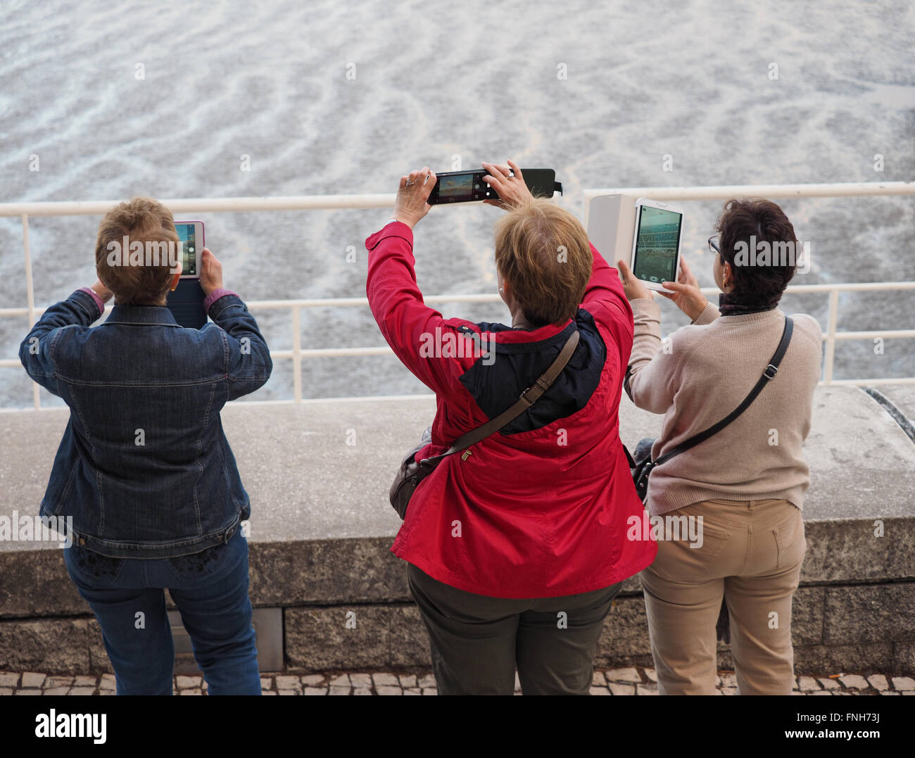 Drei Frauen mittleren Alters, die Bilder mit ihren mobilen Geräten Stockfoto