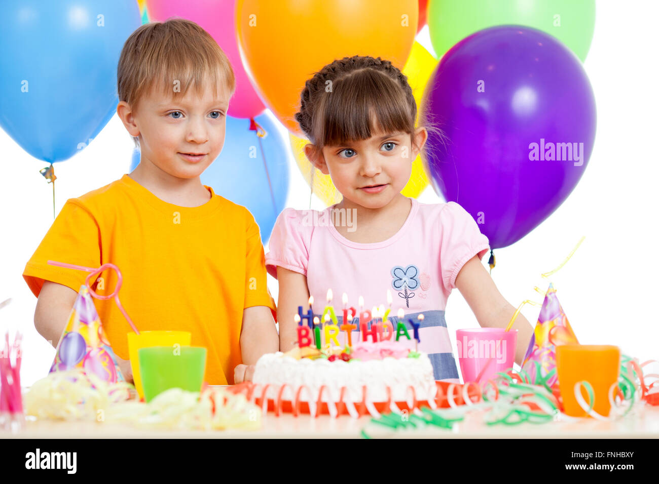 Lachende Kinder mit Geburtstag Kuchen und Farbe ballons Stockfoto