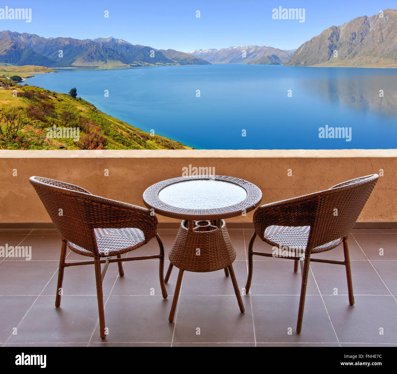 Tisch und Stühle auf der Terrasse, Blick auf einen See in Neuseeland Stockfoto