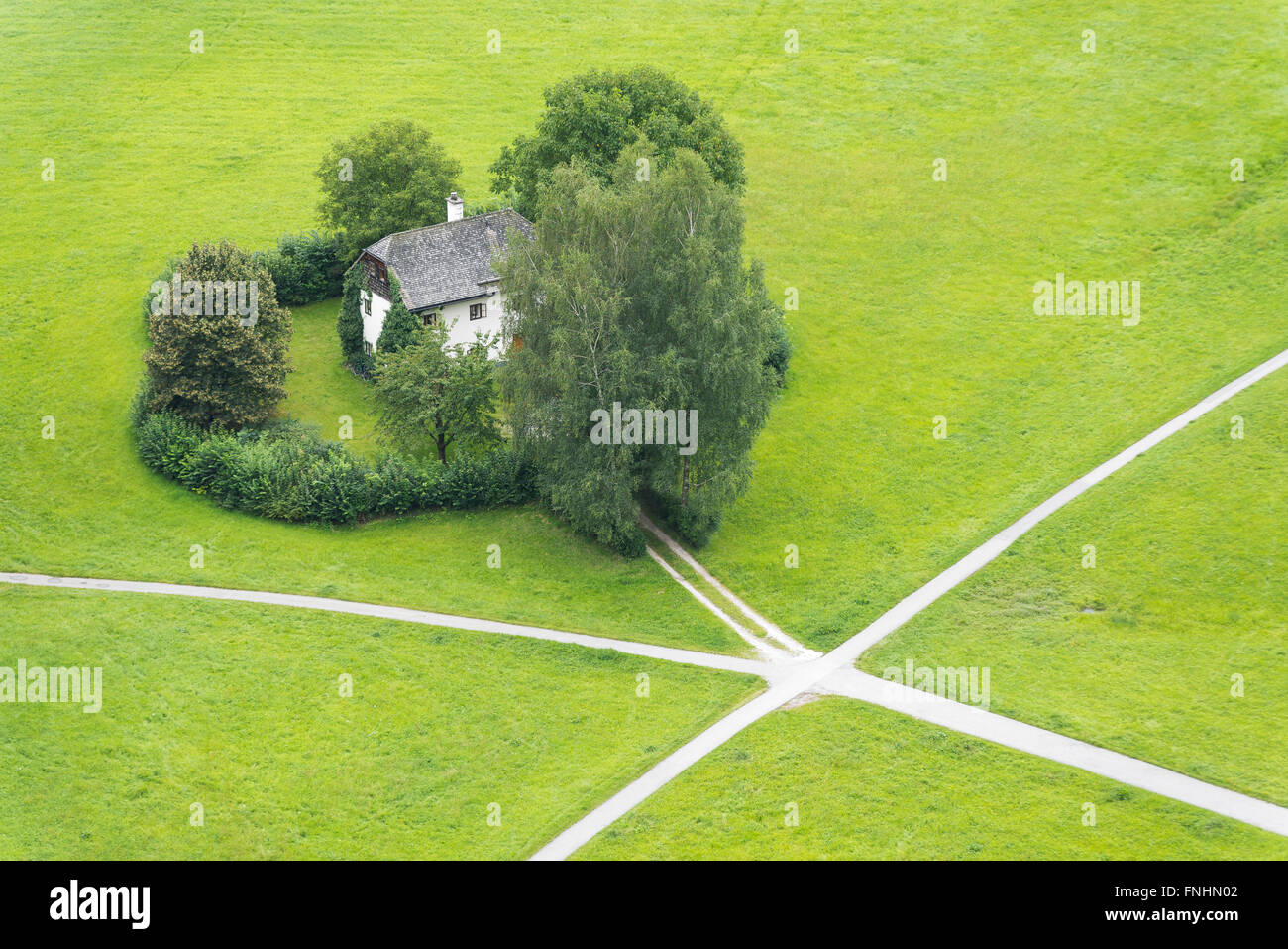 Haus und Wiesen an einer Kreuzung mit fünf Routen in Salzburg, Tirol, Österreich Stockfoto