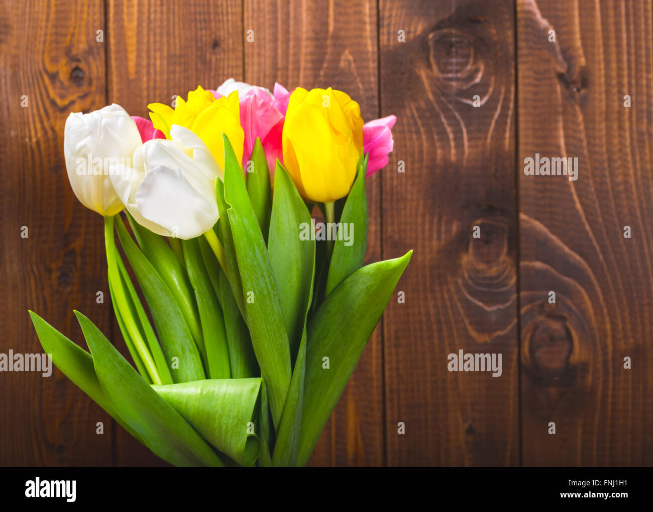 Blumenstrauß aus Tulpen vor Druckfeder Szene auf dem hölzernen Hintergrund. Ein Blumenstrauß für den 8. März, oder zum Valentinstag Stockfoto