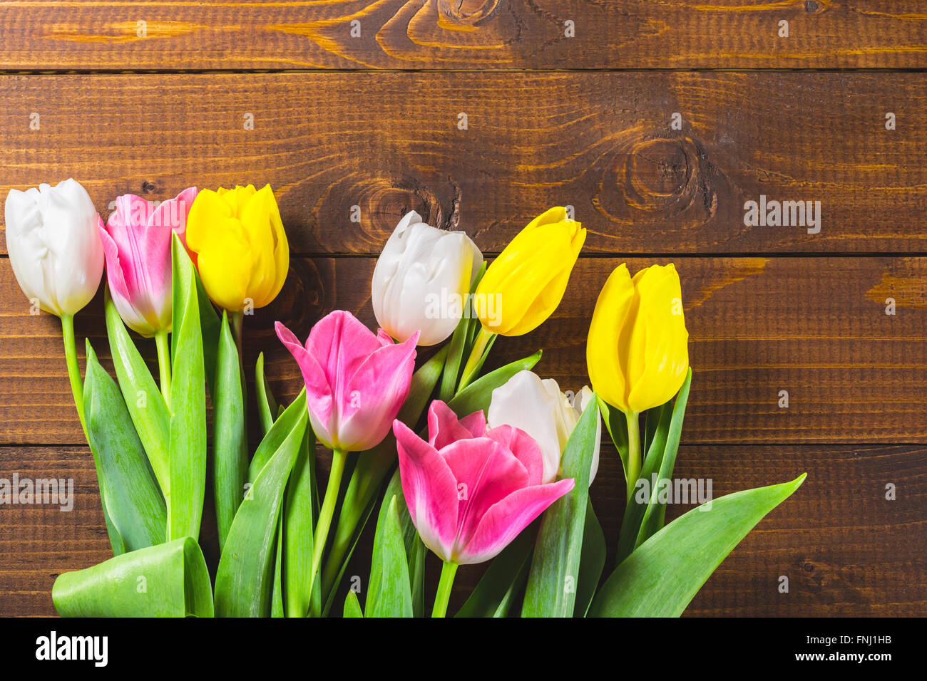 Blumenstrauß aus Tulpen vor Druckfeder Szene auf dem hölzernen Hintergrund. Ein Blumenstrauß für den 8. März, oder zum Valentinstag Stockfoto