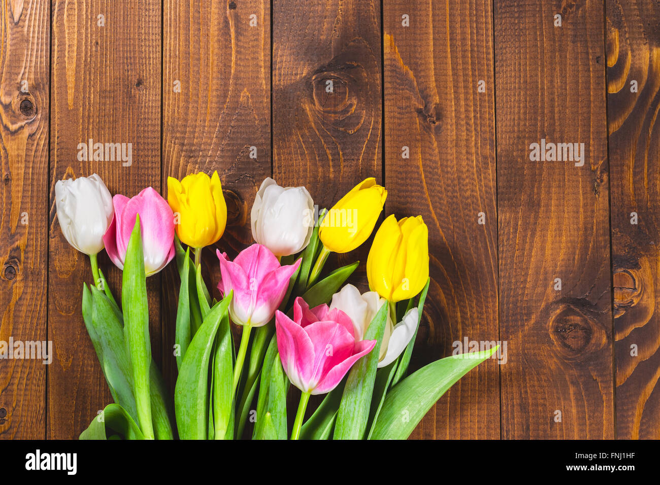 Blumenstrauß aus Tulpen vor Druckfeder Szene auf dem hölzernen Hintergrund. Ein Blumenstrauß für den 8. März, oder zum Valentinstag Stockfoto