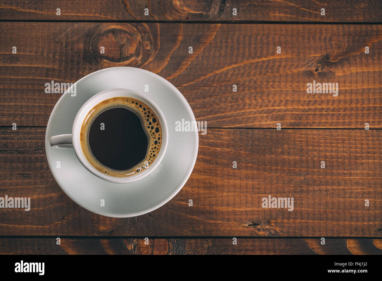 Schöne weiße Tasse mit Untertasse auf alten Vintage Holz- Hintergrund Stockfoto