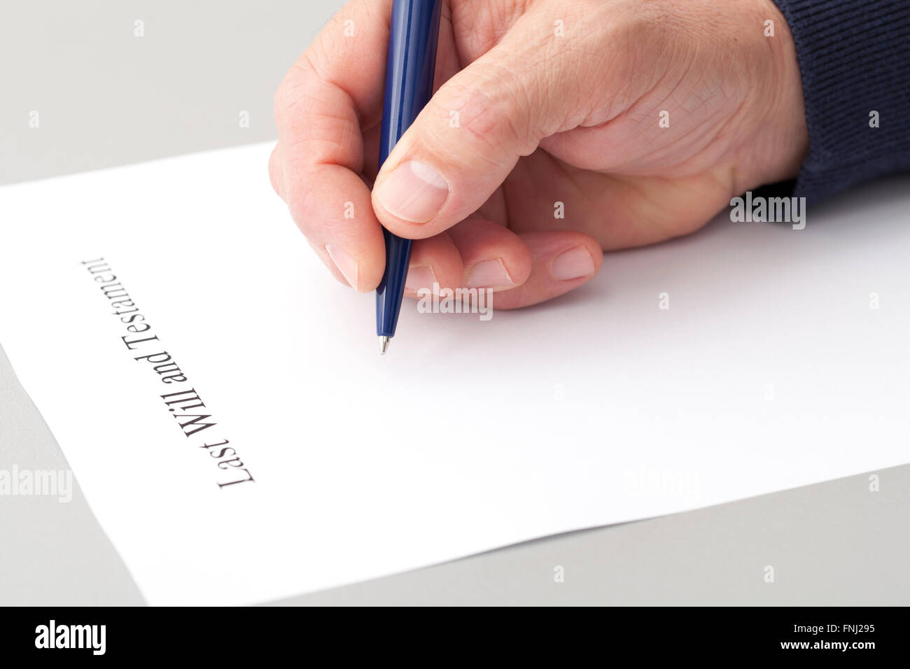 Mann Wringen letzter Wille und Testament auf ein leeres Formular von Pen in einem Notariat. Stockfoto