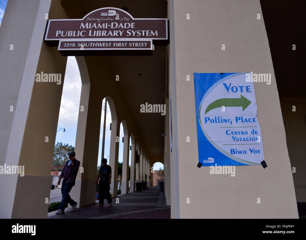 Miami, USA. 15. März 2016. Fußgänger Fuß mit einem Wahllokal in Miami, Florida, USA, 15. März 2016. New Yorker Milliardär Entwickler Donald Trump am Dienstag nahm einen Schritt in Richtung sperren bis 2016 republikanischen Präsidentschaftskandidaten nach einem entscheidenden Sieg in der primären, Winner-takes-All-Florida nach lokalen Medien Projektion. © Yin Bogu/Xinhua/Alamy Live-Nachrichten Stockfoto