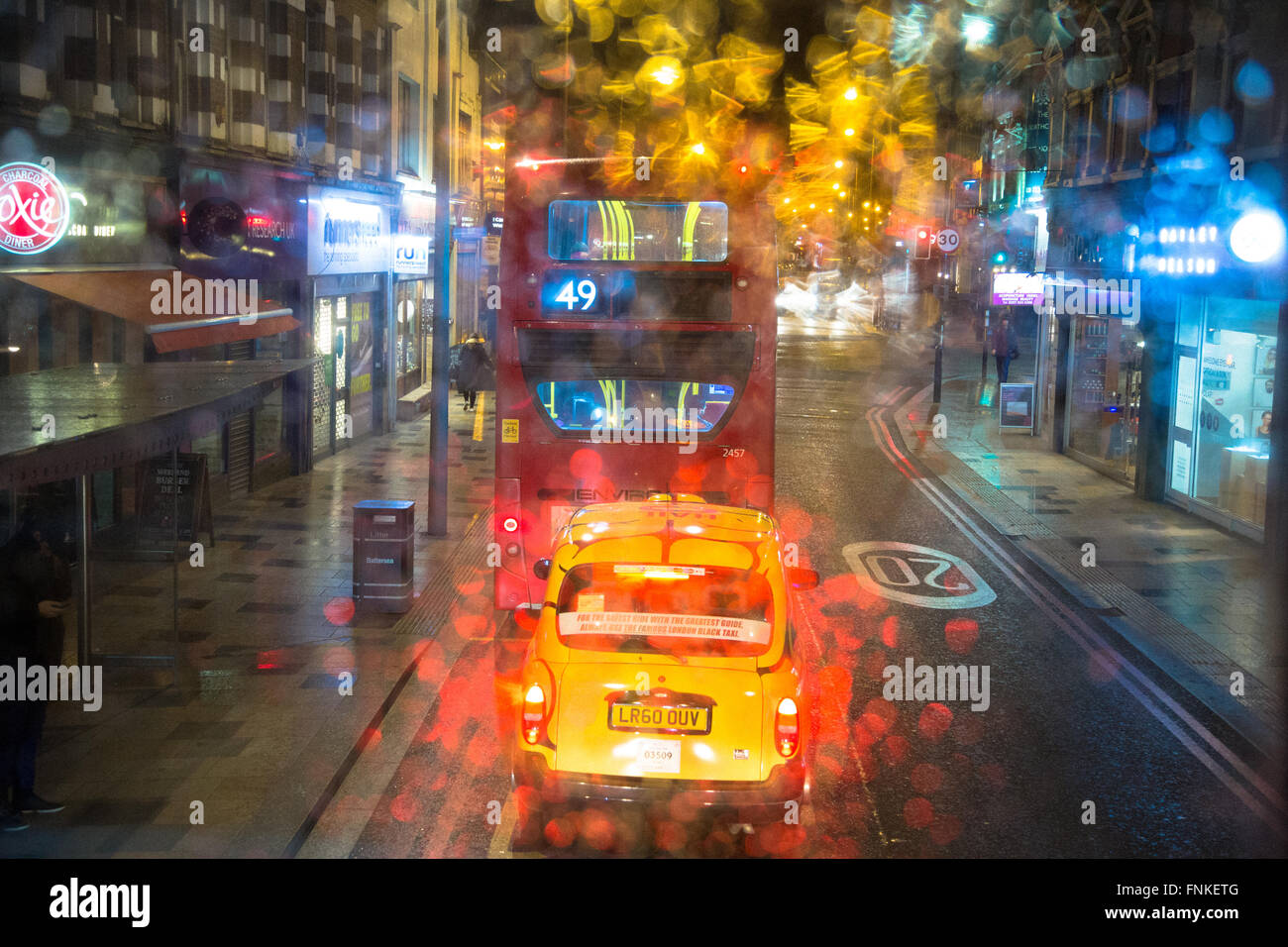 Einem regnerischen Abend auf dem Oberdeck eines London-Bus nach einem anderen Londoner Bus reisen. Schuss durch nasse Fenster aufgenommen. Stockfoto