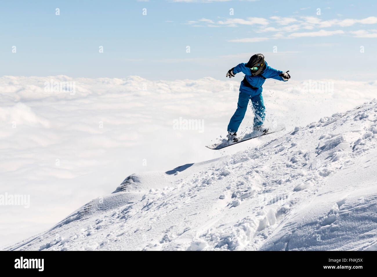 Freestyle-Snowboarder springt von oben auf einem Berg Vitosha Berg mit Wolken bedeckt. Er beteiligt sich an einem befreit Stockfoto