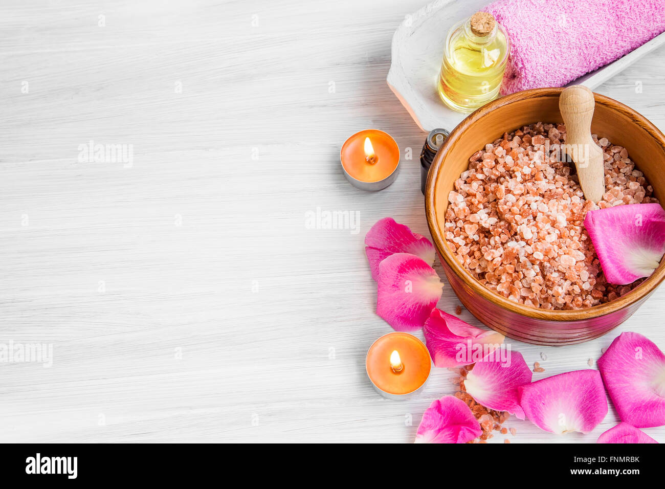 Spa mit stiegen, Badesalz, Rosenblätter, Handtuch und Körperpflege Öl und Kerzen Stockfoto