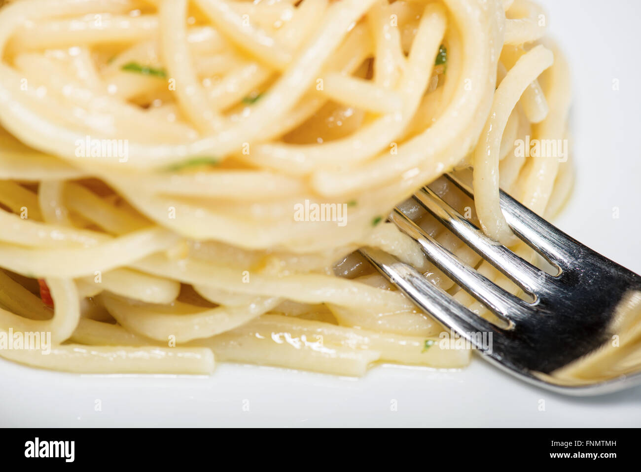 Spaghetti mit Knoblauch, Öl und Peperoni mit Petersilie und Gabel am ...