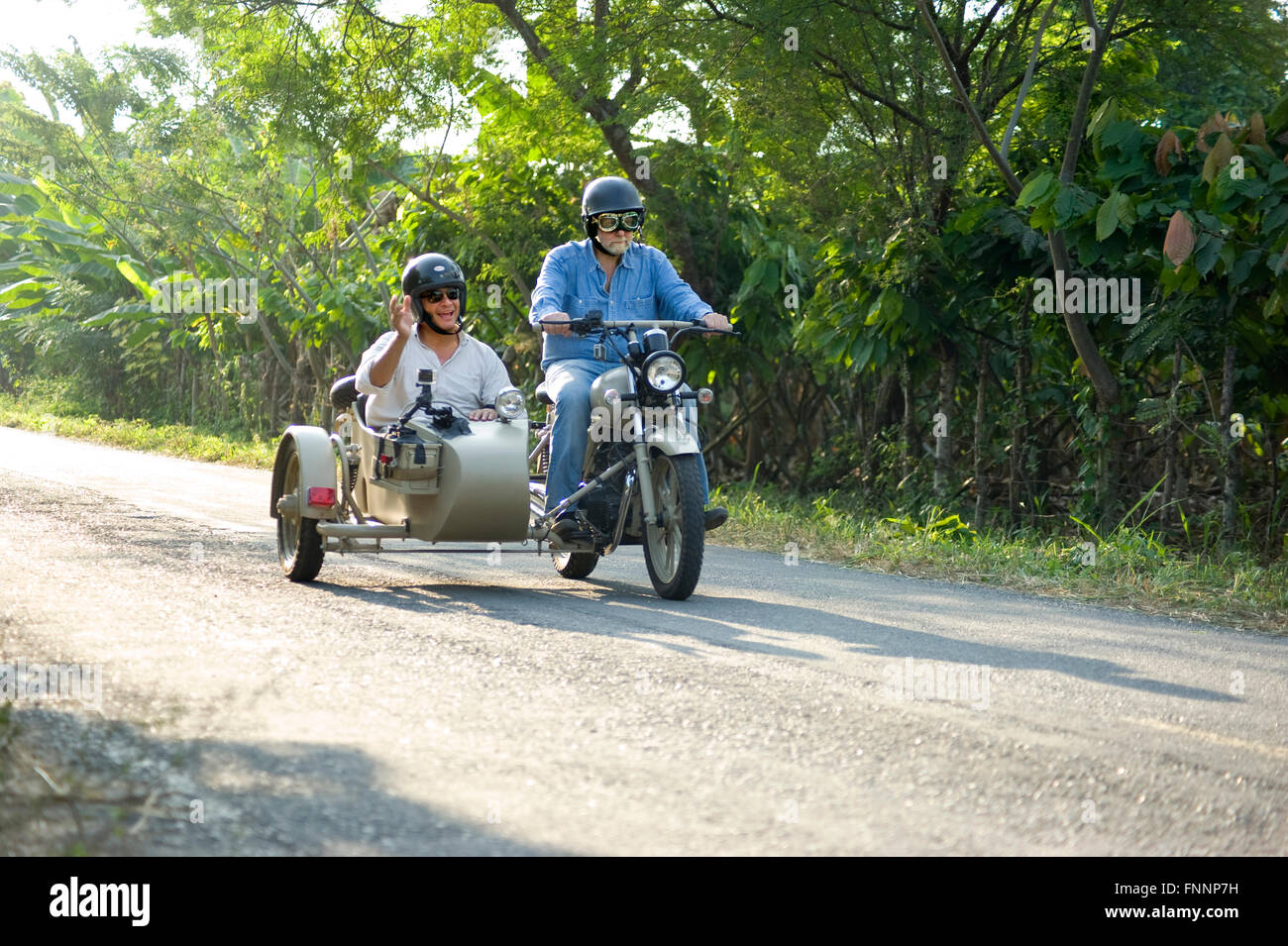 Präsident Rafael Correa und Showmaster Peter Greenberg fahren einen Oldtimer  Motorrad mit Beiwagen in der Kakao-Region während der Dreharbeiten von  Ecuador: The Royal Tour Stockfotografie - Alamy
