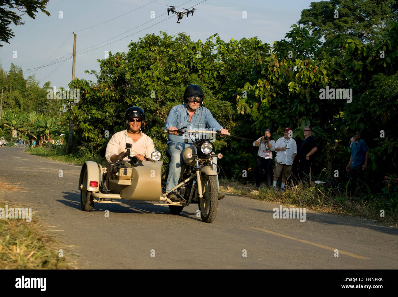 Präsident Rafael Correa und Showmaster Peter Greenberg fahren einen Oldtimer Motorrad mit Beiwagen hinter der Mannschaft und unter eine Drohne mit Kamera während der Dreharbeiten von Ecuador: The Royal Tour. Stockfoto
