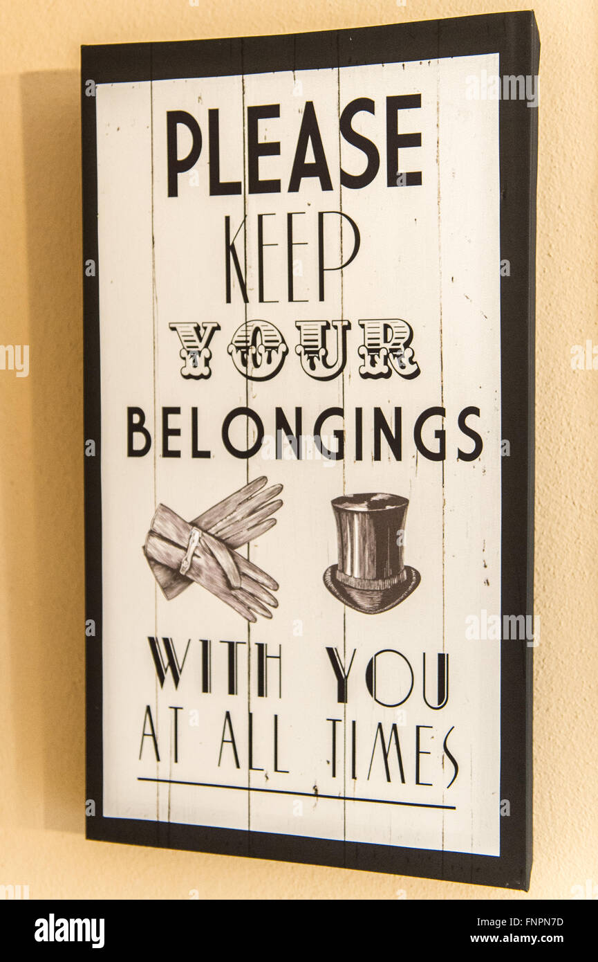 Ein Vintage-Effekt "Bitte halten Sie Ihre Habseligkeiten mit Sie zu allen Zeiten" Schild an die Wand gehängt. Stockfoto